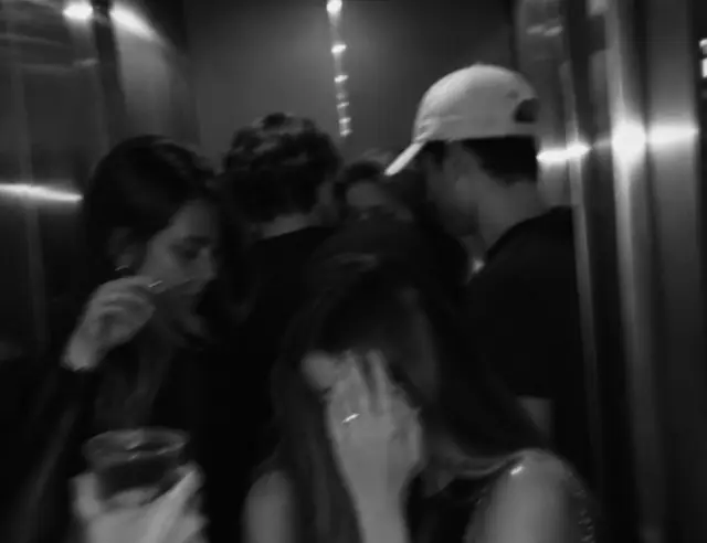 amigos espremidos num elevador de madrugada, foto em preto e branco tremida